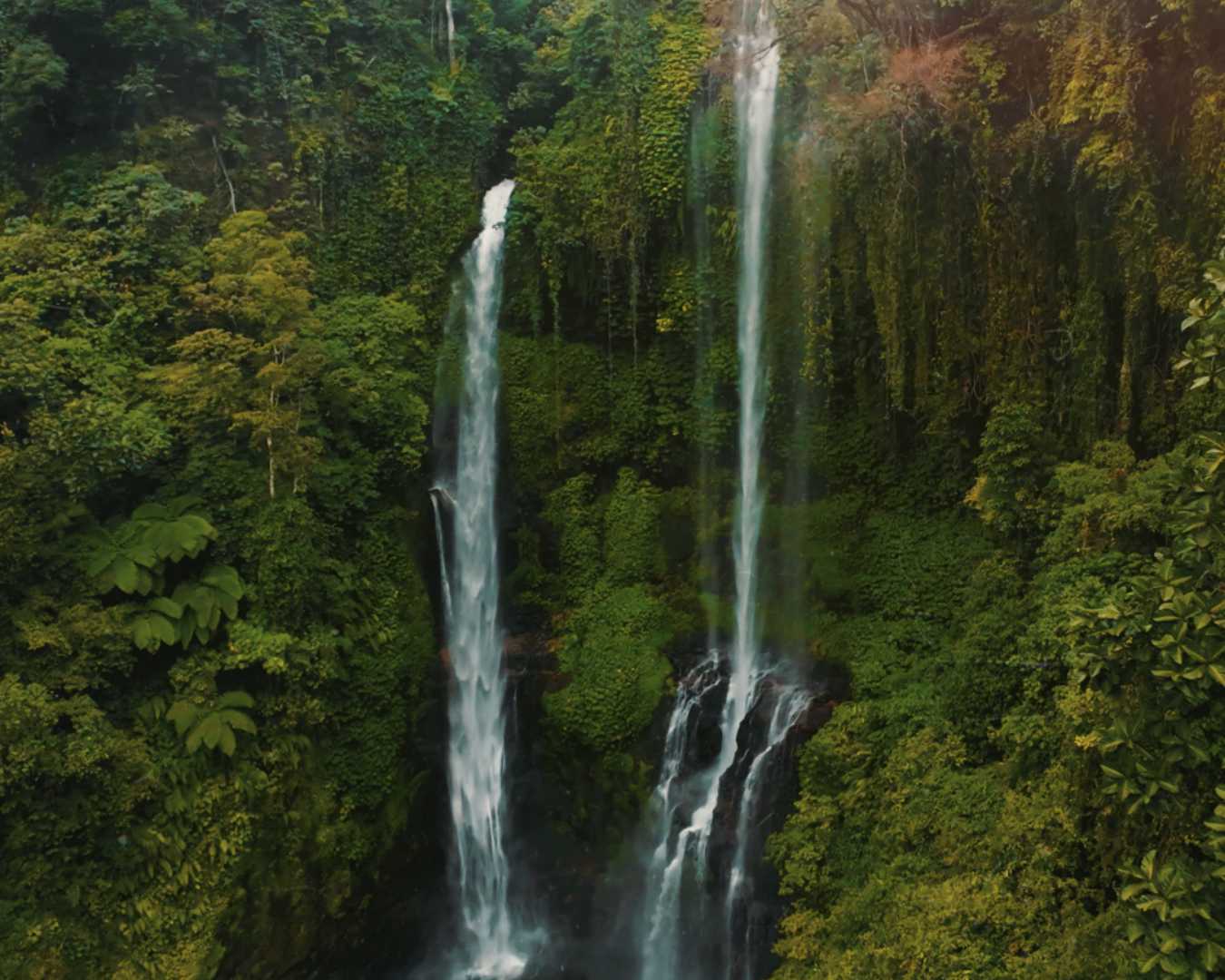 Multiple waterfalls cascading down a lush cliff at Sekumpul in North Bali